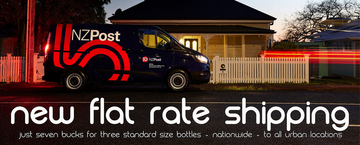 A dark blue NZPost delivery van parked in front of a house at dusk, with large promotional text across the bottom reading 'new flat rate shipping' and smaller text about standard size bottles nationwide.